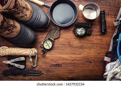 Outdoor travel equipment planning for a mountain trekking camping trip on wooden background. Top view - vintage film grain filter effect styles - Powered by Shutterstock