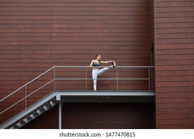 Outdoor Urban Fitness Workout. Sporty Woman Stretching Legs. Female Athlete Cooling Down After Exercising.