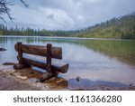 Outdoor view of wooden chair in the lakeshore located in gran teton, beautiful landscape with the string lake and the mountain behind