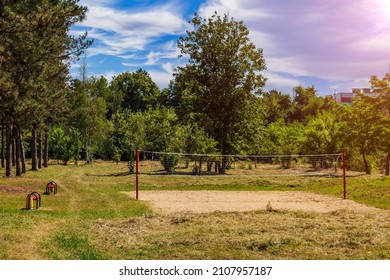 An Outdoor Volleyball Court Is Overgrown With Grass Due To The Lockdown During The Covid-19 Coronavirus Pandemic. Background With Copy Space For Text Or Inscription