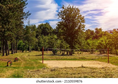 An Outdoor Volleyball Court Is Overgrown With Grass Due To The Lockdown During The Covid-19 Coronavirus Pandemic. Background With Copy Space For Text Or Inscription