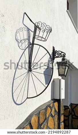 Outdoor wall decoration, half old bicycle wheel and its reflection on the wall, selective focus