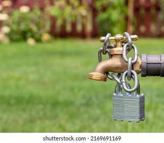Outdoor water faucet with lock and chain. Water restriction, supply and shortage concept - Shutterstock ID 2169691169