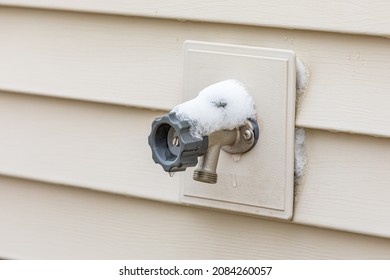 Outdoor water spigot covering in snow during winter. Home repair, maintenance and weatherproofing concept. - Shutterstock ID 2084260057