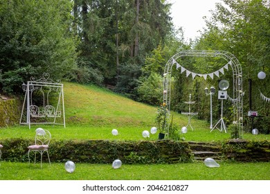 An Outdoor Wedding Altar In The Backyard With A Decorative Heart-shaped Swing And Balloons