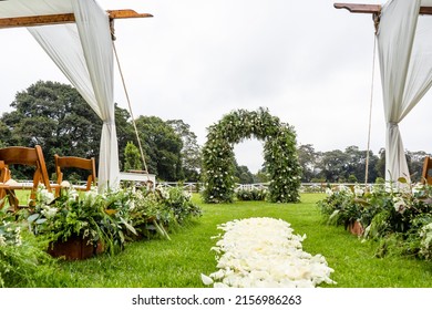 An outdoor wedding venue with a flower petal aisle on a field