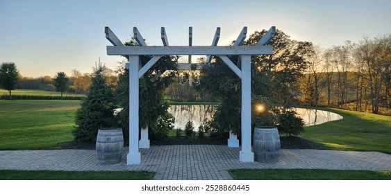 outdoor white wedding arbor with sun setting in the background - Powered by Shutterstock