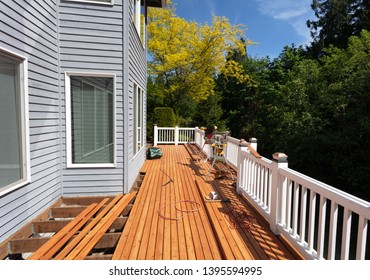 Outdoor Wooden Deck Being Remodeled With New Red Cedar Wood Floor Boards Being Installed    