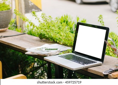 Outdoor Workspace With Laptop And Smart Phone On Wooden Table