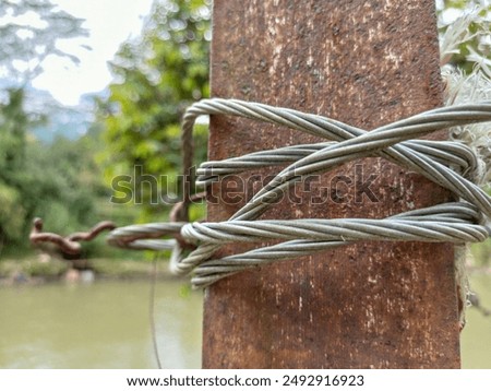 outdoors, close up of steel wire wrapped around rusty iron on blurred background.