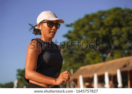 outdoors fitness lifestyle portrait of young attractive and athletic woman jogging happy on city park doing intervals workout in athlete training a running session concept
