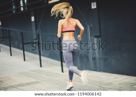 Similar – Frau in Sportbekleidung mit Kopfhörern, die wie ein Smartphone aussehen.