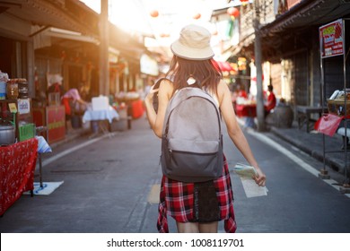Outdoors lifestyle rear view of young woman. walking on the holiday festival outdoor market ,Festive mood,  Traveler and holidays, Backpacker concept.