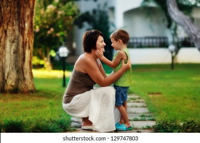 Outdoors In The Park Mother And Son On A Walk Hug