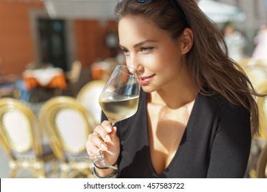 Outdoors portrait of a beautiful wine tasting tourist woman.