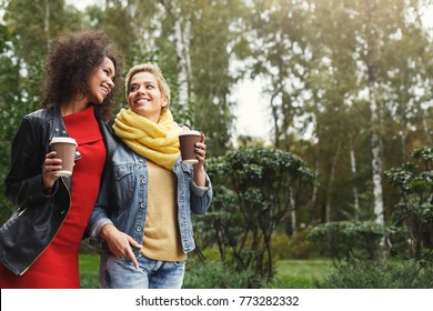 공원에 있는 여자 친구들의 실외 초상화. 추운 계절에 도시산책을 하는 캐주얼 차림의 다문화 소녀들은 커피를 마시고 즐거운 시간을 보낸다. 도시생활과 우정 스톡 사진