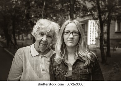 Outdoors Portrait Of A Grandmother And Her Granddaughter Teenager. Black And White Photo