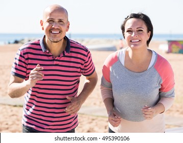 Outdoors Portrait Of A Smiling Running Mature Couple 40-60 Years Old