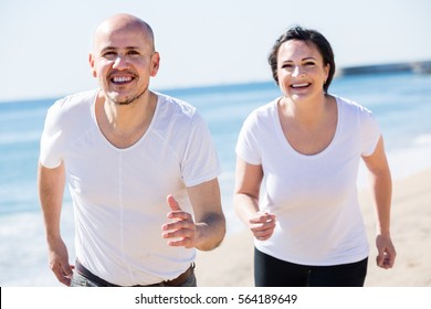 Outdoors Portrait Of A Smiling Running Mature Couple Together