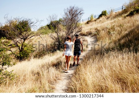 
Outdoors summer portrait of a young couple in love embrace by the sea on a hot day. Vacation, travel of young people