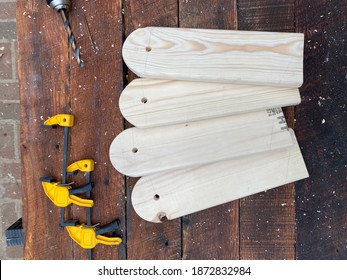 Outdoors Wood Working DIY Project. Four Wooden Legs For Cornhole Boards Surrounded By Saw Dust And Clamps On Top Of A Workbench