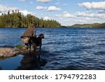 Outdoorsmen with his German shorthair pointer dog fishing at the lake 