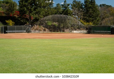 Outfield view of a kid's recreational baseball field with dugouts and a backstop. 