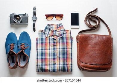 Outfit of traveler, student, teenager. Overhead of essentials for modern young person. Different objects on white wooden background.