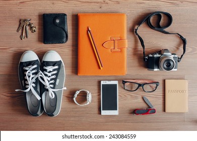 Outfit of traveler, student, teenager, young woman or guy. Overhead of essentials for modern young person. Different objects on wooden background. - Shutterstock ID 243084559
