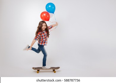 Outgoing girl using skateboard in the studio