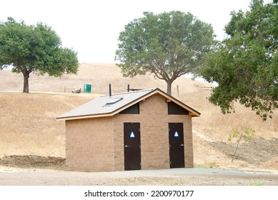 Outhouse Bathroom Facility In A Drought Parched Park Landscape. Gender Neutral Bathrooms.