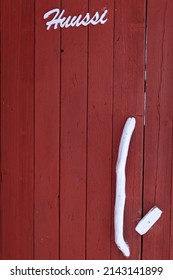 An Outhouse Door With A Sign In Finnish And A Handle