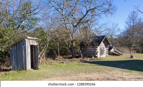 An Outhouse, A Small Log Building And A Storm Cellar
