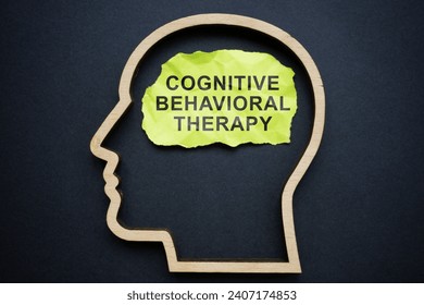Outline of the head and inscription Cognitive behavioral therapy CBT on piece of paper.