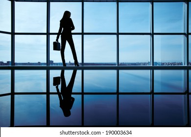 Outline of office worker with briefcase standing by the window - Powered by Shutterstock