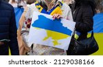 Outline of Ukraine. Protester holding a sign with Ukrainian flag map. Demonstration against a war and Russia invasion on Ukraine. Russian attack protest, manifestation.