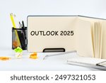 OUTLOOK 2025 in a notebook on a table on a light background