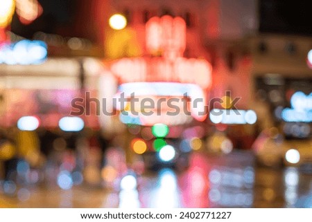 Out-of-focus, blurred background in the night with street lights and the lights of Moulin Rouge on the other end of the street