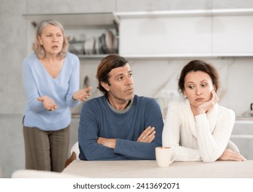 Outraged elderly female pensioner scolds her son and daughter-in-law for infantile behavior, unworthy behavior - Powered by Shutterstock