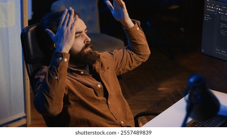 Outraged software engineer perplexed by impossible to remove bugs appearing while coding on computer desktop. Teleworking IT admin feeling baffled by script errors, putting hands on head, camera A