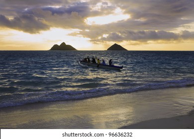 An Outrigger Canoe Heads Out To Sea At Sunrise In Hawaii