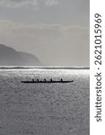 Outrigger canoe paddling at Waialua Bay at the island of Oahu, Hawaii, USA against backlight