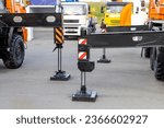 Outriggers of new wheeled cranes on wooden pads. Wheel cranes in a dealership or at an industrial fair. Stability and safety of wheeled vehicles during lifting operations