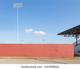 Outside A Baseball Field With Lights And Stadium And Wall And Blue Sky