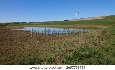 outside between lakes and green fields and blue sky 