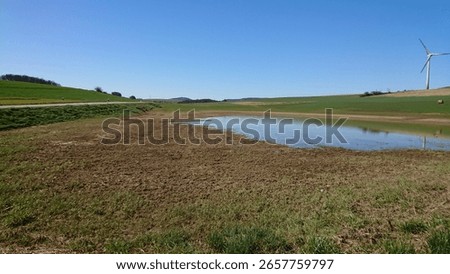 outside between lakes and green fields and blue sky 