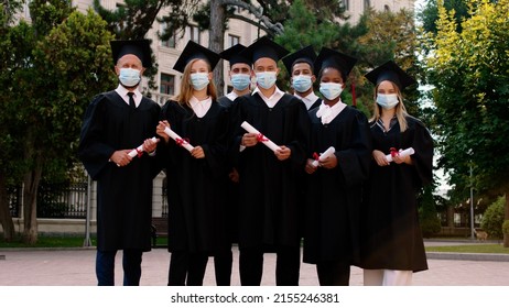 Outside Of The College Group Of Graduates Multiracial Students After The Graduation Posing In Front Of The Camera In The Group Wearing Protective Mask They Are In The Pandemic Of COVID-19