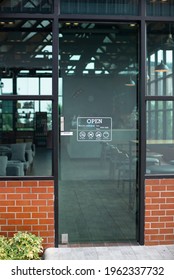 Outside glass door of modern cafe restaurant with Open sign, No smoking, No pet, no food and drink, Dayli Mon-fri. Loft coffee shop exterior with red brick wall background and eco green glass - Shutterstock ID 1962337732