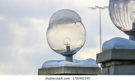 An Outside Light Fixture Covered In Snow In The Day Time