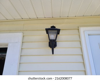 An Outside Light Fixture On The Side Of A Home.